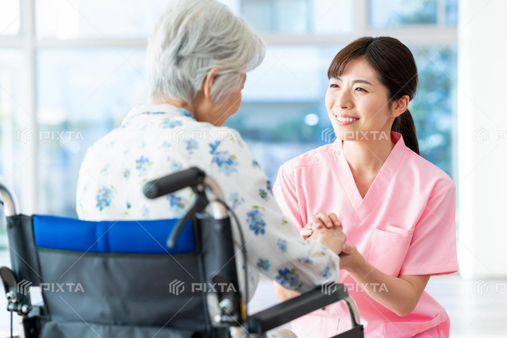 車椅子の高齢者と笑顔で話す介護士
