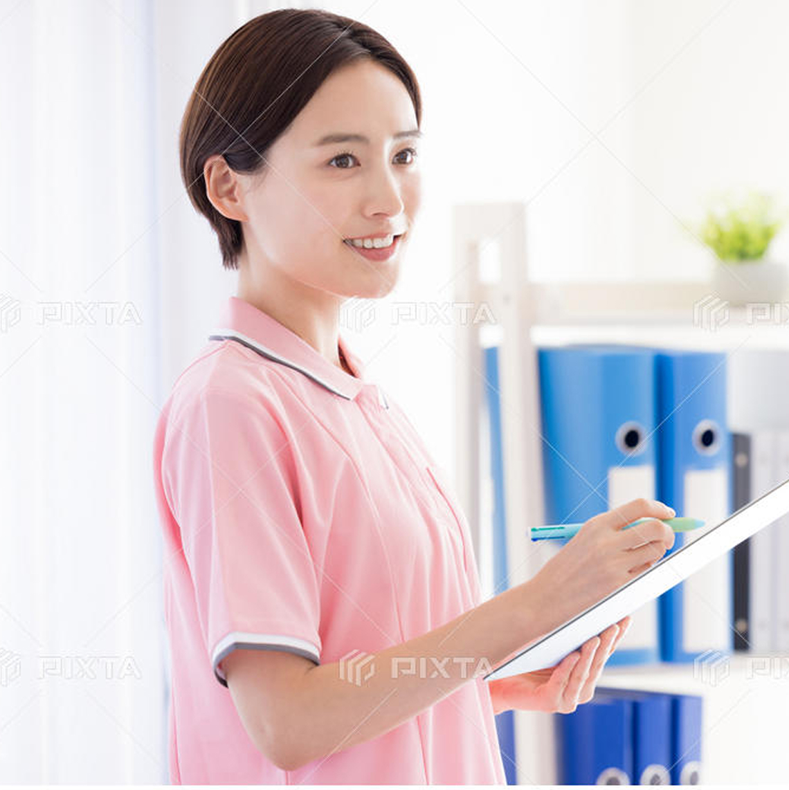 訪問介護員の女性スタッフが笑顔でこちらを見る