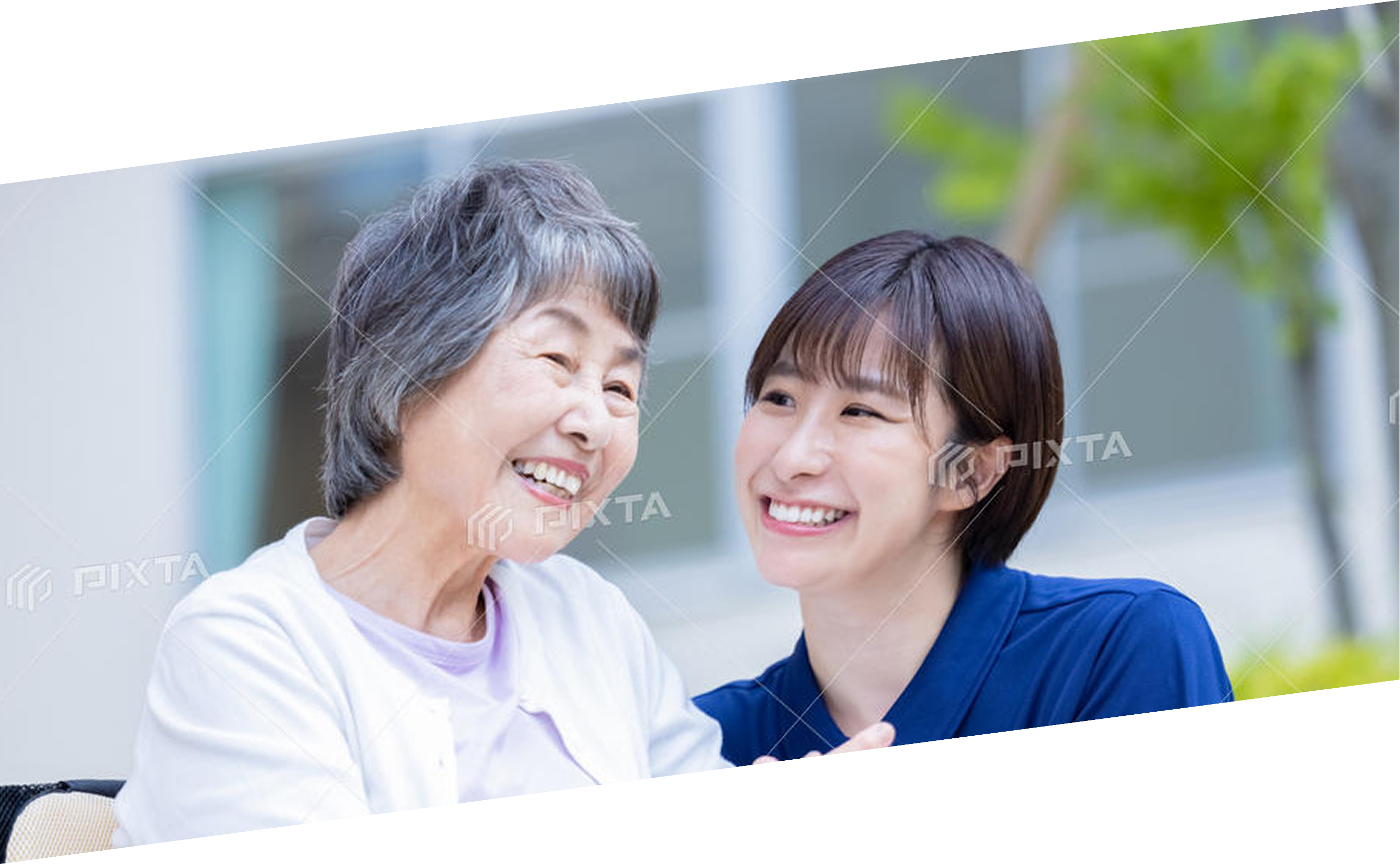 公園を歩く高齢者と介護士の後ろ姿